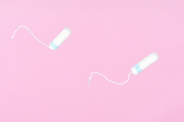 Medical female flyeng tampon on a pink background. Hygienic white tampon for women. Menstruation, means of protection.
