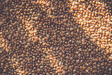 Raw brown buckwheat background with sunshine