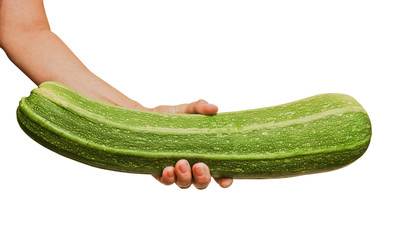 Fresh green zucchini in a female hand. Healthy vegan food. Isolated. Close-up.
