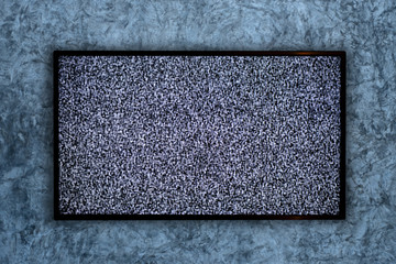 TV on the concrete wall and no signal sign on a Television screen