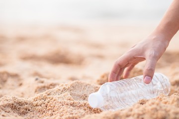 hand with bottle on the beach.