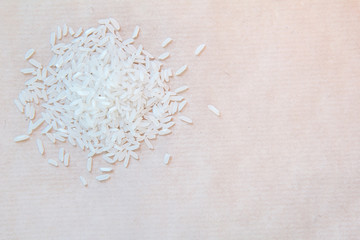 Pile of white rice on a light brown background. Top view