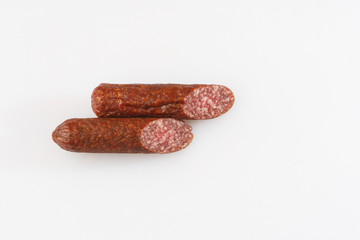 Industrial manufacture of sausages. Smoked sausage on a wooden rustic table with addition of fresh aromatic herbs and spices, natural product from organic farm, produced by traditional methods.