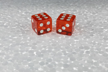 Two red glass dice on a gray plastic surface. Jackpot, win.
