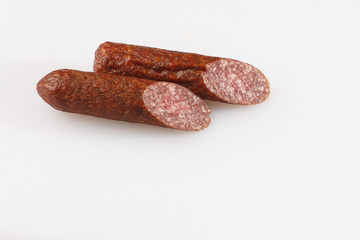 Industrial manufacture of sausages. Smoked sausage on a wooden rustic table with addition of fresh aromatic herbs and spices, natural product from organic farm, produced by traditional methods.