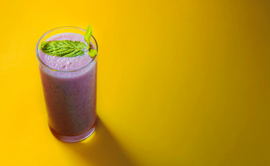 Minimal view of strawberry smoothie over pastel yellow background, copy space