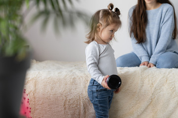 offended little girl pouted, stands near the bed. relationship parents and children.