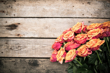 Naklejka na ściany i meble Bouquet of roses on wooden background. Vintage floral background
