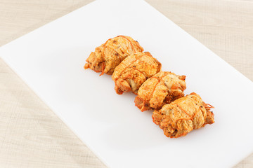 Chicken roll in grid decorated lettuce leaf isolated on wooden background. Fresh meat product whole and partly sliced. Chicken ham, and slices of tasty chicken meat. Natural product from organic farm.