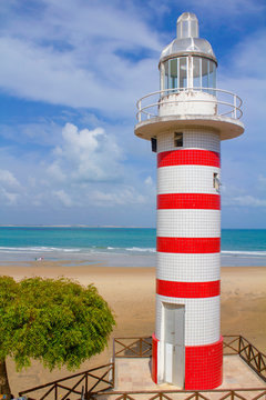 Sunny day in summer, in Paracuru tourist beach in Ceara, northeastern Brazil, beautiful tourist itinerary, with lighthouse on the beach and tents.