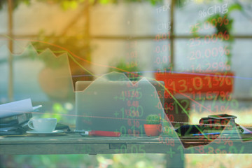 Double exposure of stock market graph and business desk for finance investment and business. Investment and economic concept