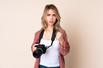 Young photographer girl over isolated background frustrated by a bad situation