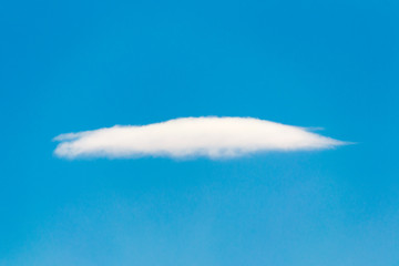 Fototapeta na wymiar single white cloud on clear blue sky background