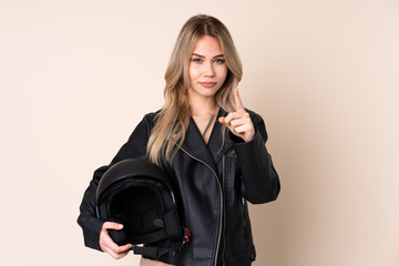 Russian girl with a motorcycle helmet isolated on beige background frustrated and pointing to the front