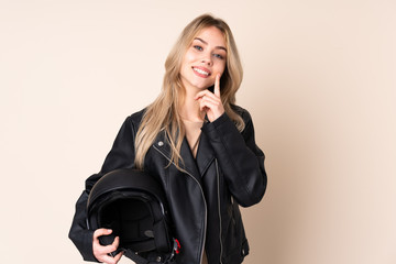 Russian girl with a motorcycle helmet isolated on beige background smiling with a happy and pleasant expression