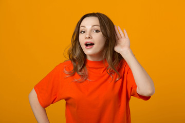 beautiful young woman in a t-shirt on a yellow background