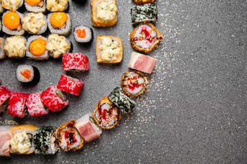 A large set of various rolls and sushi. Hats from the sauce. Baked rolls. Close-up