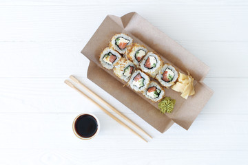 Japanese sushi to go. Biodegradable take away craft box with sushi maki rolls california. Asian food with smoked eel, avocado, cucumber and red caviar. Healthy snack delivery