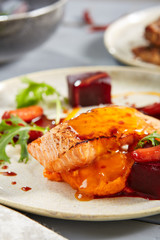 Salmon fillet with beet in herbs and passion fruit sauce close up