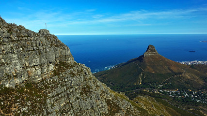 Cape Town Against the background of the blue Atlantic Ocean, a cliff of an unusual shape is clearly visible - the Lion's head. Away from the city of Cape Town. Clouds in the sky.
