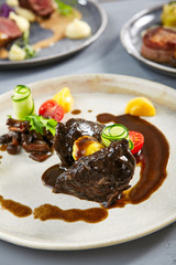Veal cheeks with smoky honey mushrooms and squash in beige plate