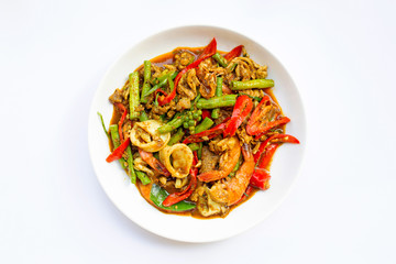 Spicy stir fried shimp, squid and pork with Thai Southern chili paste and longbean on white background.