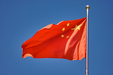 Flag of the Peoples Republic of China against the blue sky