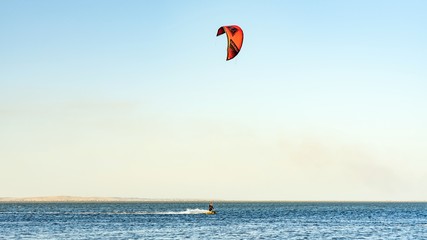 Man kitesurfer rides kite. Black Sea coast on sunny day. Blagoveshenskaya. Anapa, Russia.