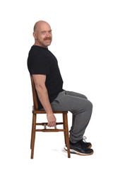 bald man with sportswear sitting looking at camera on white background