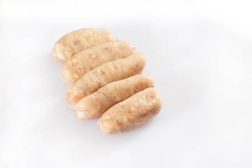 Raw pork beef sausages on white background. Traditional German homemade sausages. Delicious raw meat for barbecue. Advertising for meat shop and farm. Top view. Space for text