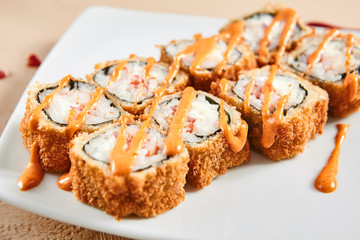 Rolls with shrimps, cream cheese, tomatoes and Spicy sauce in white plate top view