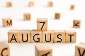 August 7 - from wooden blocks with letters, important date concept, white background random letters around