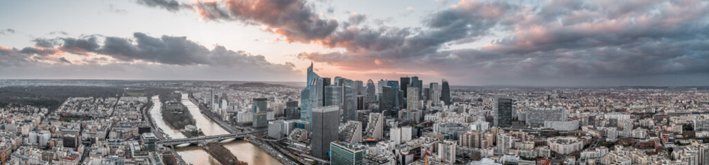 Panoramic aerial drone shot of la defense skyscraper complex with clouds during sunset hour