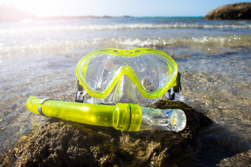 snorkel put on the rock seaside beach with shallow coral.