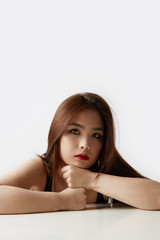 Vertical portrait of beautiful asian woman with long hair posing in studio on white studio background. Isolated.