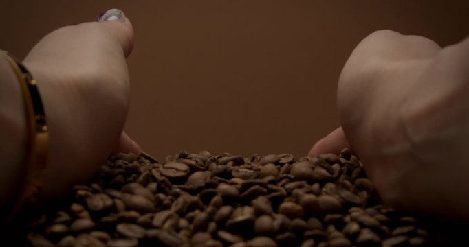 female hand took a coffee beans and coffee beans falling down from hands first 1st person plan