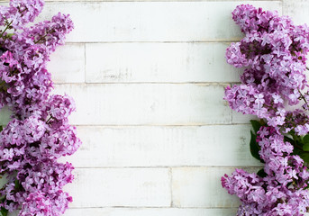 bright blooming purple lilac on a light background imitating a tree. Wooden background, branches and flowers of lilac laid out on the background. Photophone for decor