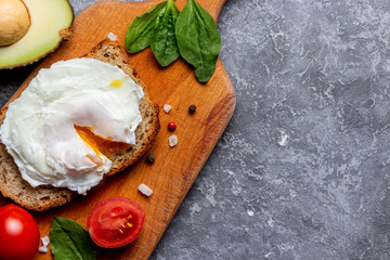 Eco lunch with a poached egg on bread with seeds on a wooden tray