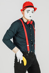 Clown with red suspenders and red hat on white background