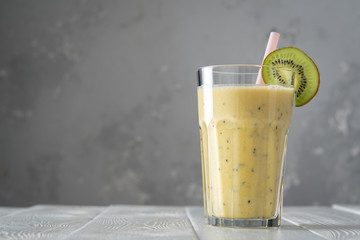 Protein shake with kiwi on white wooden boards. Fresh milkshake with kiwi. Smoothies.
