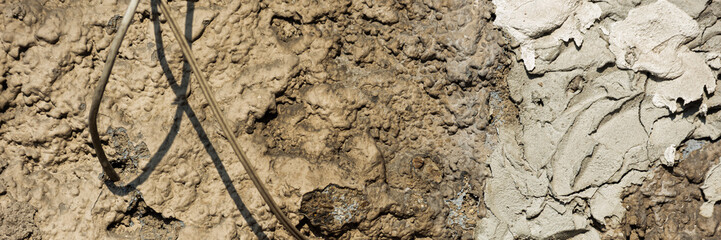 Wires on the long background of a rough stone wall with putty