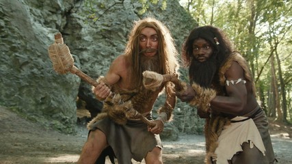 Aboriginal wild caveman of prehistoric period hunting for animal food in the forest. Primitive homo...