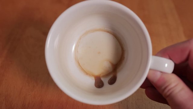 Looking inside an empty coffee cup with just leftover drops
