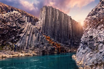 Foto op Plexiglas Amazing Nature landscape of Iceland. Impressively beautiful Studlagil canyon with basalt columns and colorful sky during sunset. Tipical Iceland scenery. Iconic location for photographers and bloggers © jenyateua