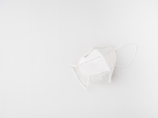 white face mask isolated on a white surface vertical top view