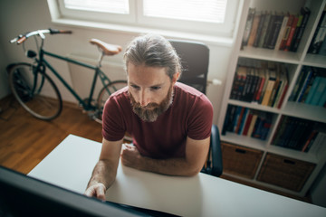 Fototapeta premium Bearded man working form his home office desk