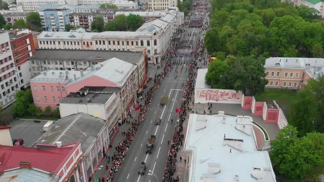 Gomel, Belarus - 05/09/2019: Victory Day parade along the main street are military and holiday people, top view over houses, flight over the city rooftops