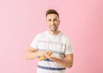 Handsome young man with shampoo on color background