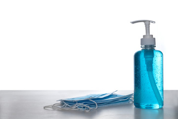 Face mask with alcohol sanitizer gel hand wash on wood table and white background with copyspace for text or design.