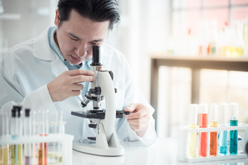 Scientist looking through microscope in laboratory with copy space using as background science, medical , education, biology, chemistry concept.